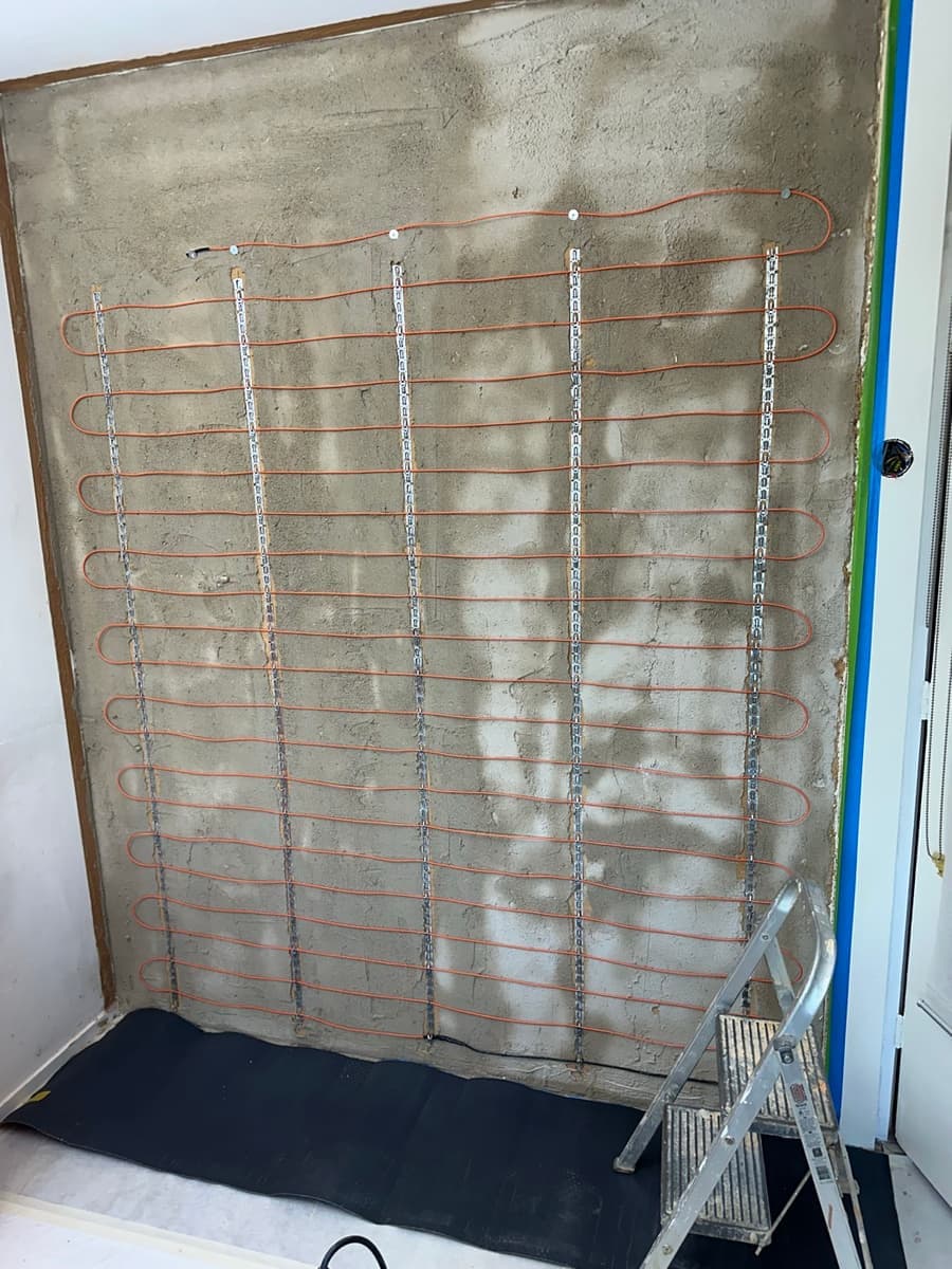 Verwarmingskabel in lussen op de muur, klaar voor de leem